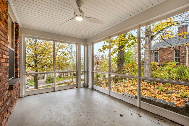 unfurnished sunroom with ceiling fan