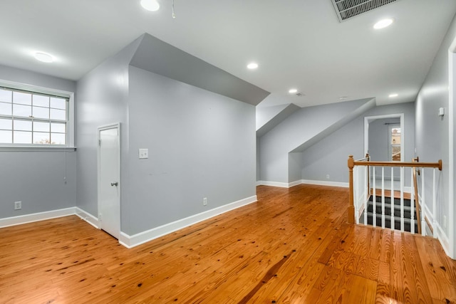 additional living space with light hardwood / wood-style flooring