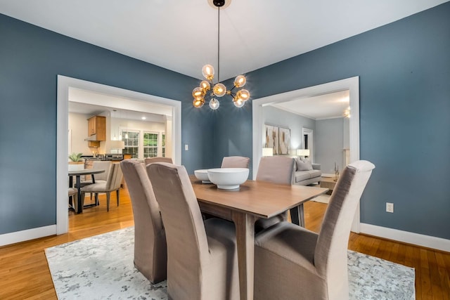 dining area featuring light hardwood / wood-style floors and an inviting chandelier