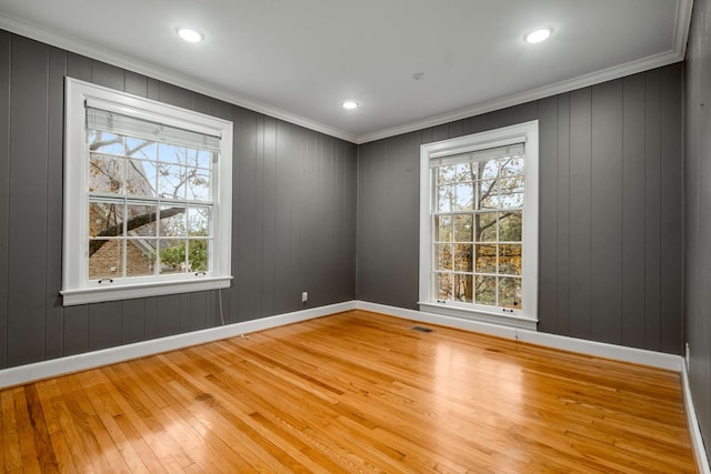 empty room with crown molding and hardwood / wood-style floors