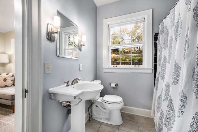 bathroom with tile patterned floors, toilet, and walk in shower