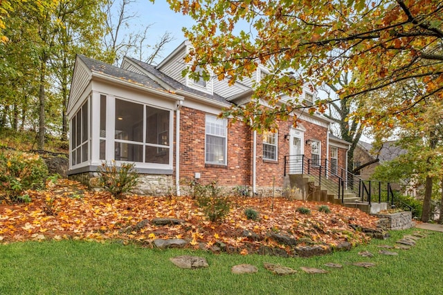 view of side of home with a sunroom and a yard