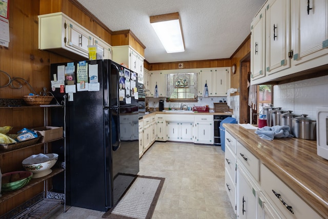 kitchen with sink, tasteful backsplash, a textured ceiling, white cabinetry, and black appliances