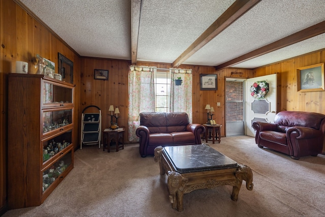 carpeted living room featuring wooden walls, a textured ceiling, and beamed ceiling