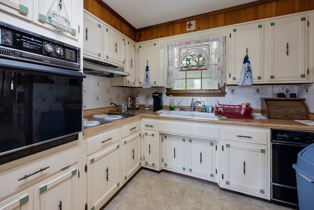 kitchen with a textured ceiling, oven, sink, and white cabinets