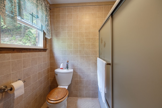 bathroom featuring tile walls, a shower with shower door, toilet, and tile patterned flooring