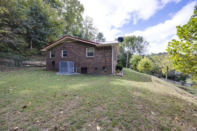 view of side of property featuring central AC unit and a yard