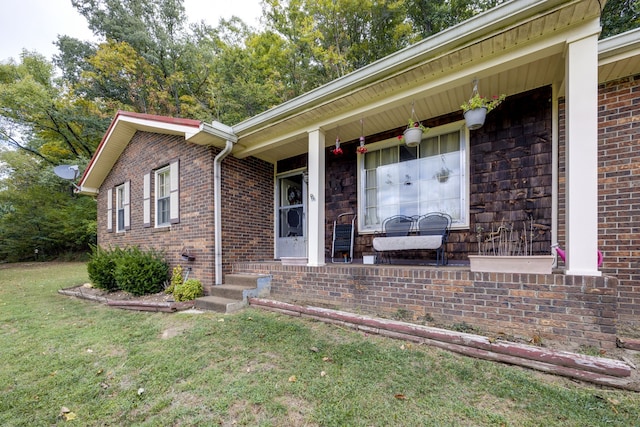 entrance to property with a lawn and a porch