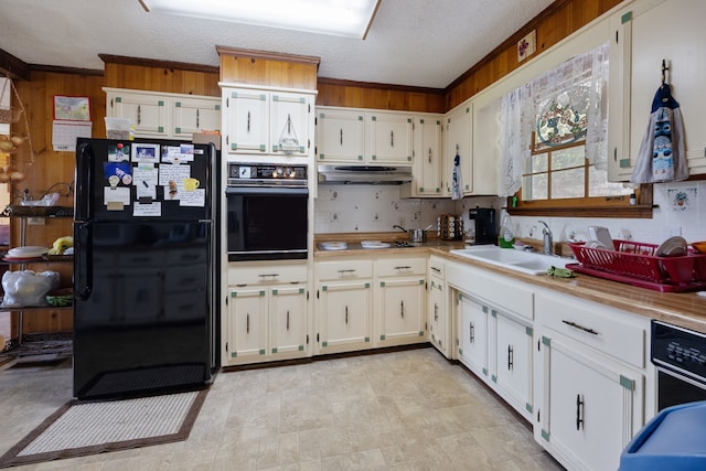 kitchen featuring a textured ceiling, sink, tasteful backsplash, and black appliances