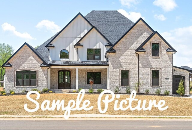 1 Ryes Chapel Rd, Southside, TN 37171 - view of front of house with board and batten siding, a shingled roof, covered porch, and brick siding
