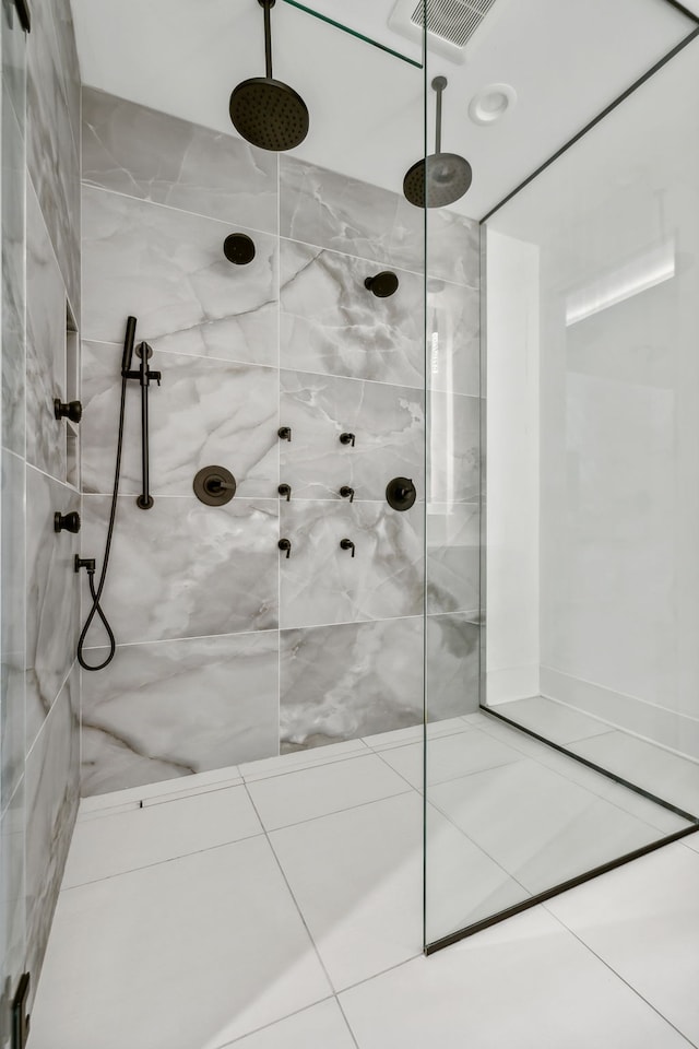 bathroom featuring tile patterned flooring, a marble finish shower, and visible vents