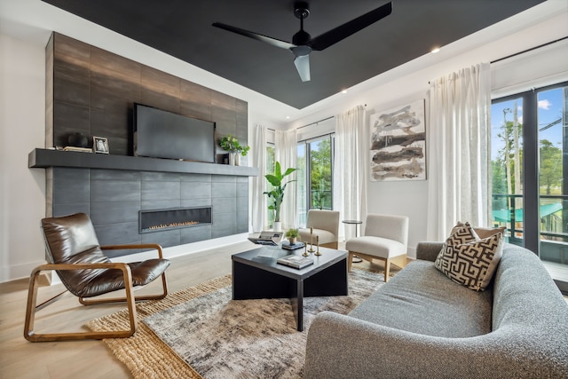 living room featuring baseboards, a tile fireplace, ceiling fan, wood finished floors, and recessed lighting