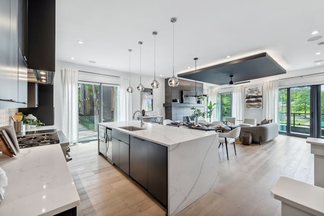 kitchen featuring a large island, light wood finished floors, open floor plan, a sink, and modern cabinets