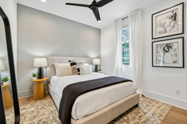 bedroom with a ceiling fan, baseboards, and wood finished floors