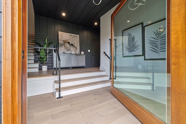 stairs with wood finished floors and recessed lighting