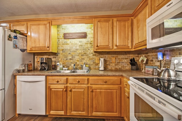 kitchen featuring backsplash, white appliances, a textured ceiling, dark hardwood / wood-style floors, and sink