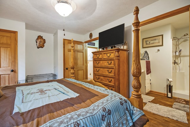 bedroom featuring ceiling fan, hardwood / wood-style floors, and a textured ceiling