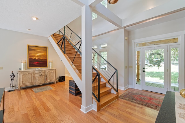 entrance foyer with a textured ceiling and light hardwood / wood-style floors