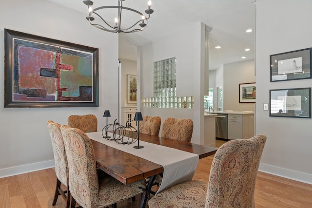 dining area featuring light wood-type flooring and a notable chandelier