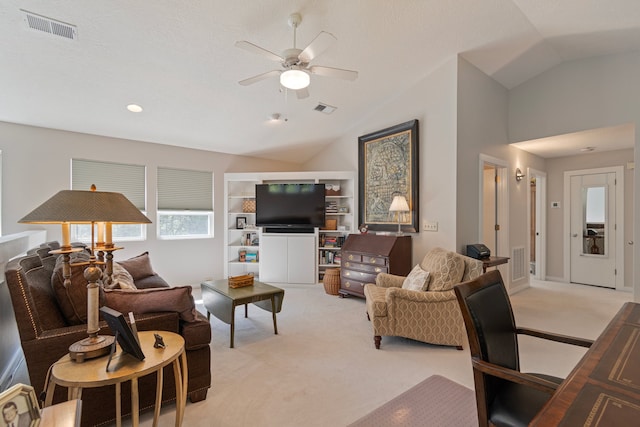 living room featuring built in features, vaulted ceiling, light colored carpet, and ceiling fan