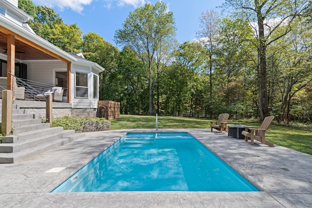 view of pool with a lawn and a patio