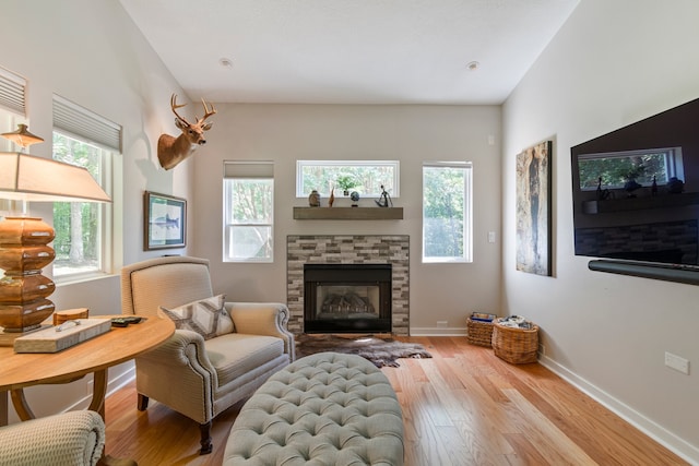 living area with a fireplace and light hardwood / wood-style flooring