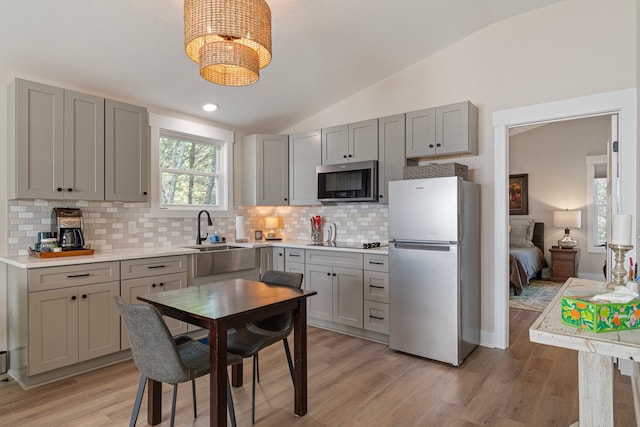 kitchen featuring light hardwood / wood-style floors, sink, lofted ceiling, and appliances with stainless steel finishes