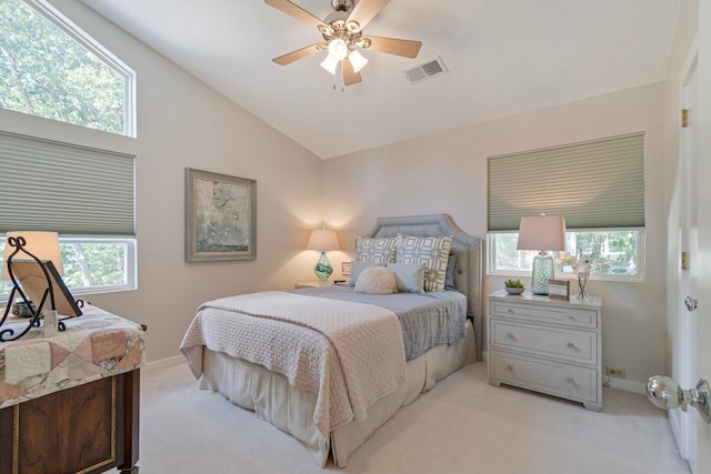 carpeted bedroom featuring multiple windows, ceiling fan, and vaulted ceiling