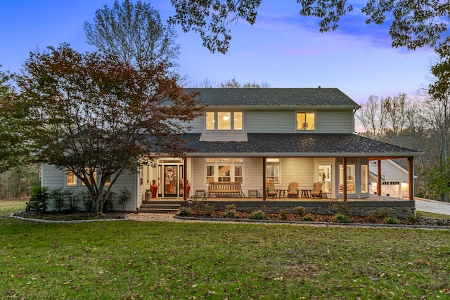 farmhouse-style home with a garage, covered porch, and a yard