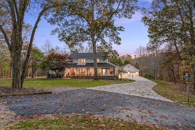 view of front of home with a garage, an outbuilding, and a yard