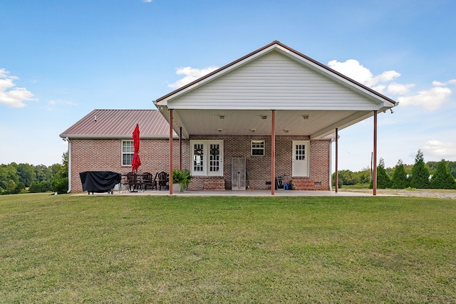 rear view of property featuring french doors, a yard, and a patio