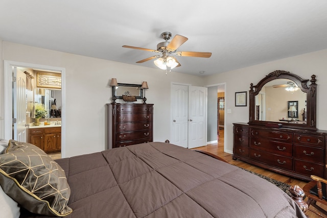 bedroom with ceiling fan, light wood-type flooring, ensuite bath, and a closet