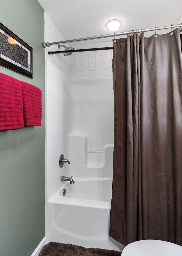 bathroom featuring shower / bath combo and toilet