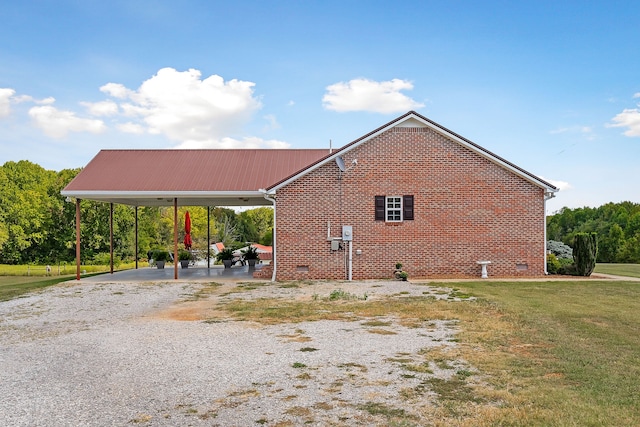 view of home's exterior with a lawn and a carport