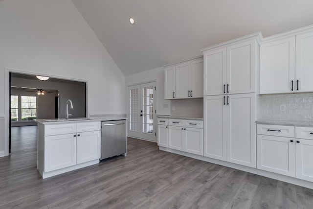 kitchen featuring high vaulted ceiling, white cabinets, light hardwood / wood-style flooring, stainless steel dishwasher, and sink