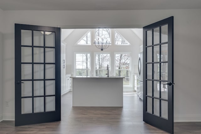 interior space featuring a notable chandelier, lofted ceiling, and hardwood / wood-style floors