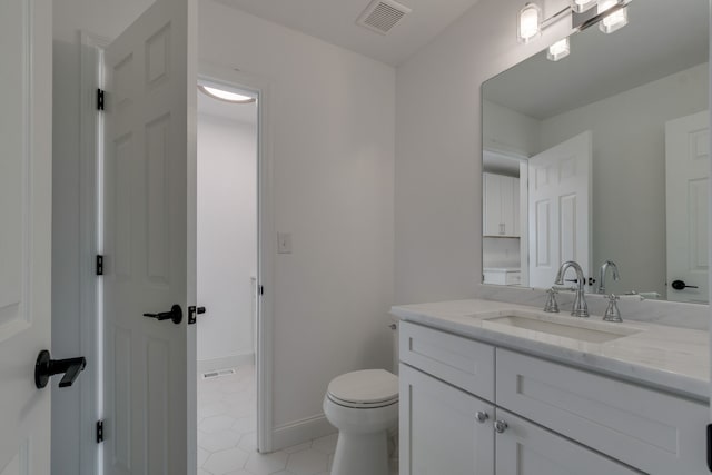 bathroom with tile patterned flooring, vanity, and toilet