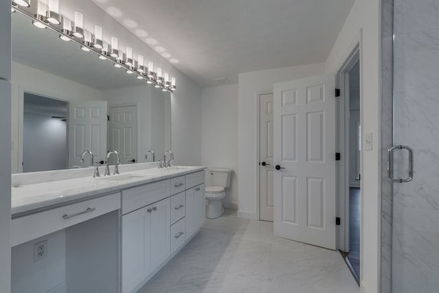 bathroom featuring vanity, a shower with shower door, and toilet