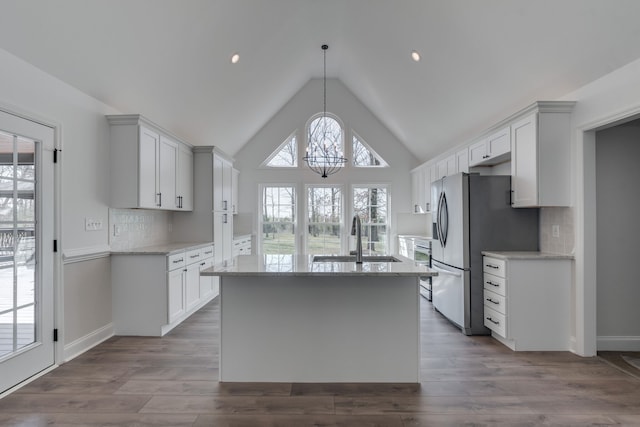 kitchen featuring decorative light fixtures, white cabinets, sink, and plenty of natural light