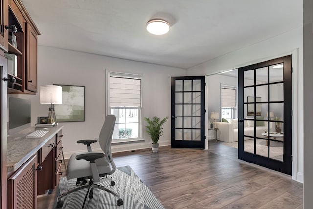 office space featuring built in desk, dark hardwood / wood-style floors, and french doors