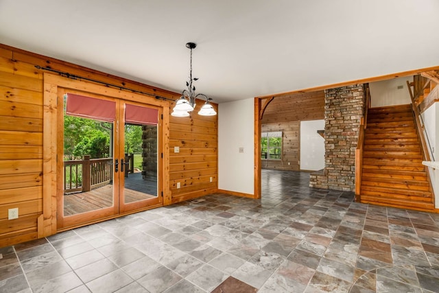 unfurnished dining area featuring wood walls and an inviting chandelier