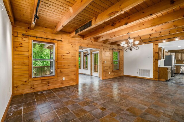 spare room featuring wooden ceiling, wooden walls, an inviting chandelier, and beamed ceiling