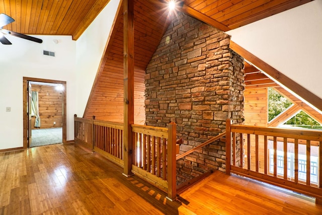 interior space with high vaulted ceiling, wood walls, wooden ceiling, and hardwood / wood-style floors