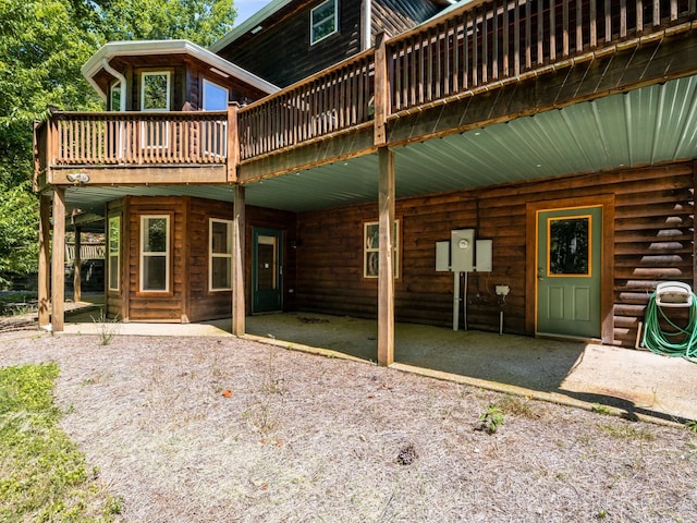 rear view of property with a deck and a patio area