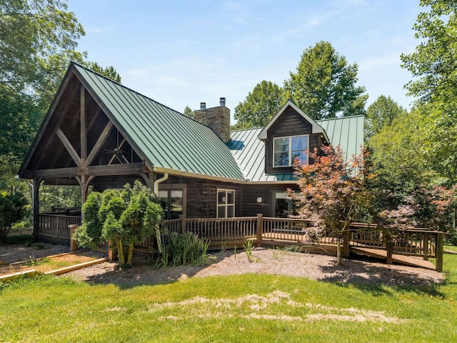 back of house featuring a lawn and a deck