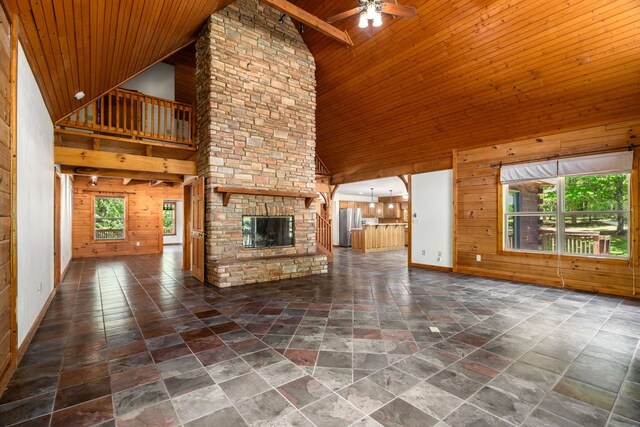 unfurnished living room featuring ceiling fan, plenty of natural light, and high vaulted ceiling