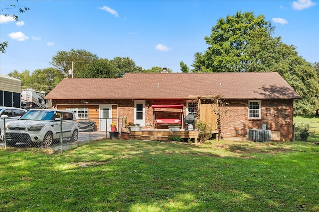 back of property featuring cooling unit and a yard