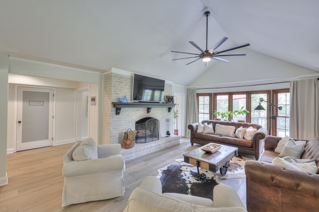 living room featuring ceiling fan, light hardwood / wood-style floors, high vaulted ceiling, and a brick fireplace