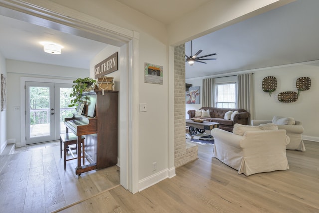 living room featuring french doors, light wood-type flooring, and ceiling fan