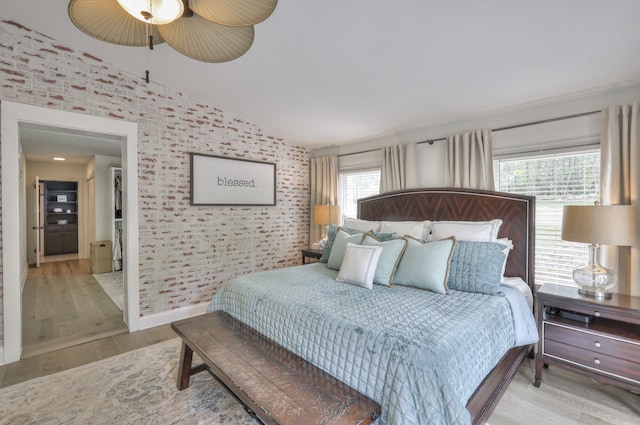 bedroom with ceiling fan, lofted ceiling, and light hardwood / wood-style flooring